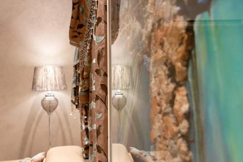 a mirror in a living room next to a lamp at Stylish Corner Maisonette - Sunflower in Birkirkara
