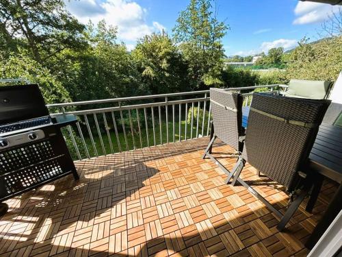 un patio con parrilla y 2 sillas en una terraza en Ferienwohnung Sauerland an der Ruhr, en Olsberg