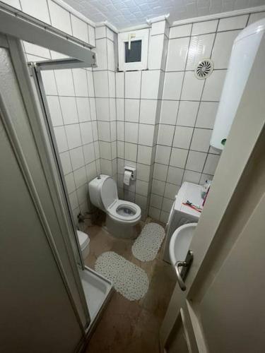 a small bathroom with a toilet and a sink at Cozy room next to Cevahir Mall in Istanbul