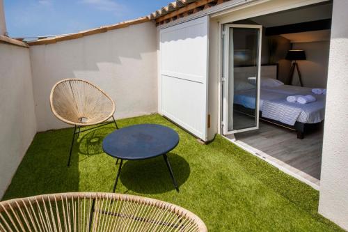 une petite arrière-cour avec une table, des chaises et un lit dans l'établissement Escapade ensoleillée avec piscine et jacuzzi - Villa Mathis Côte d'Azur, à Antibes