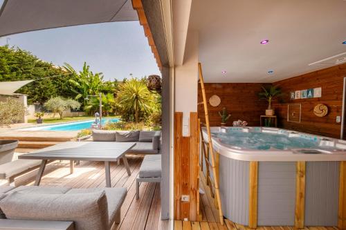- un bain à remous sur une terrasse avec une table et des chaises dans l'établissement Escapade ensoleillée avec piscine et jacuzzi - Villa Mathis Côte d'Azur, à Antibes