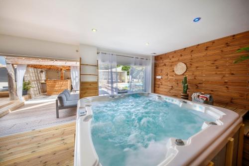 Cette chambre dispose de murs en bois et d'une grande baignoire. dans l'établissement Escapade ensoleillée avec piscine et jacuzzi - Villa Mathis Côte d'Azur, à Antibes