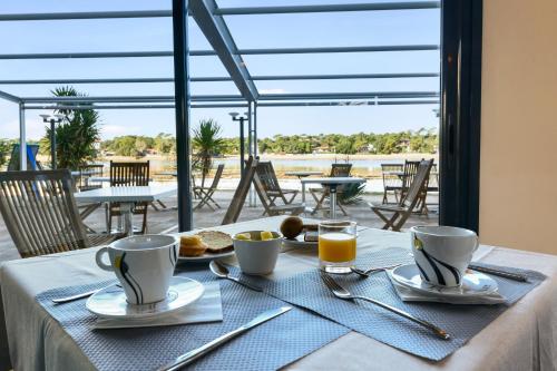 a table with two cups of coffee on a table at Hotel Le Pavillon Bleu in Hossegor