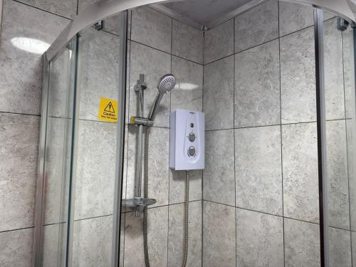 a shower with a shower head in a bathroom at Delightful Delta-Studio Apt Walk-2Leeds city WiFi in Leeds