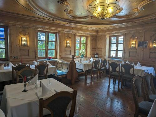 a dining room with tables and chairs and a chandelier at Hotel Ristorante Da Franco in Seefeld