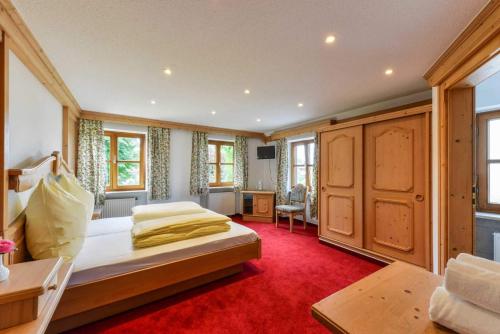 a bedroom with a bed and a red carpet at Hotel Ristorante Da Franco in Seefeld