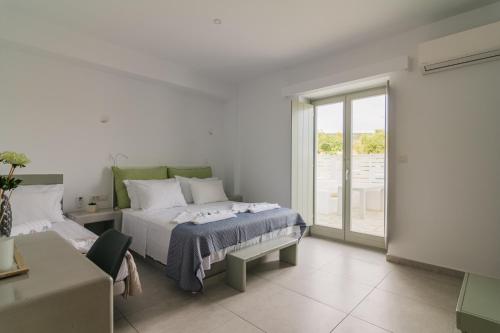 a bedroom with a bed and a couch and a window at Olive Garden Luxury Resort in Angairiá