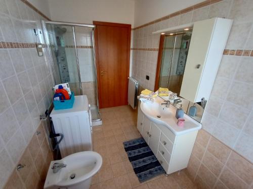 a bathroom with a sink and a toilet and a mirror at Degli Angioini Holiday Home in Caulonia Marina