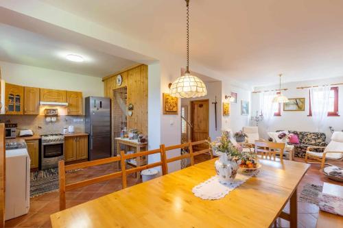 cocina y sala de estar con mesa de madera en Penzión Arkádia, en Kyselica