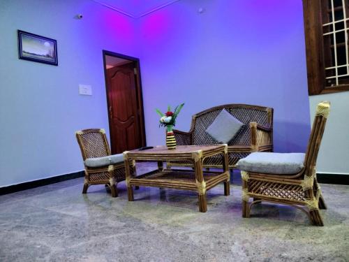 a room with a table and chairs and a purple wall at SK VILLA in Puducherry