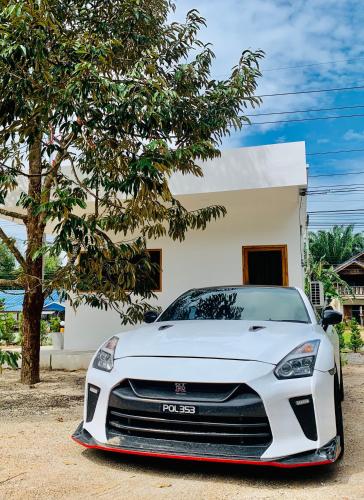 a white car parked in front of a house at Suanvadee Resort สวนวดี รีสอร์ท in Don Sak