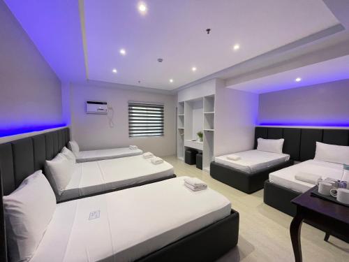a bedroom with two beds and a purple ceiling at Central Block Inn in Bacolod