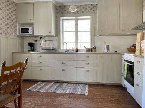 uma cozinha com armários brancos e uma janela em Årås Kvarn & Hostel em Årås