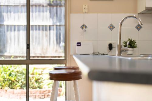 a kitchen with a counter and a stool next to a sink at family friendly 4 bedroom house close to parks in Gold Coast