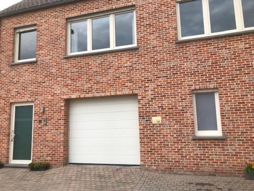 a brick building with two garage doors on it at Fokus Time out in Dessel