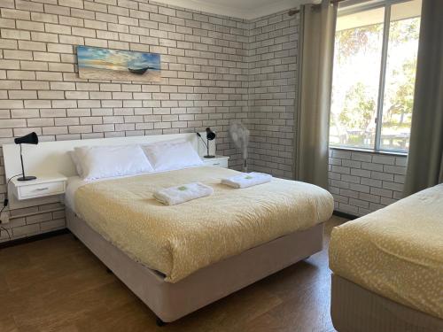 ein Schlafzimmer mit einem Bett mit zwei Handtüchern darauf in der Unterkunft Augusta Escape Holiday Units in Augusta