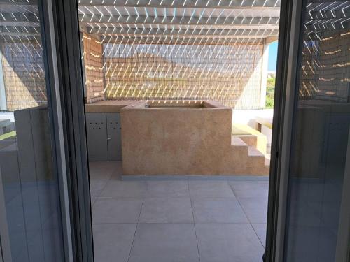 a view of a patio with a bench through a window at Olive Garden Luxury Resort in Angairiá