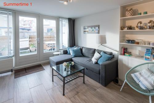 濱海貝亨的住宿－SummerTime Bergen aan Zee，带沙发和玻璃桌的客厅