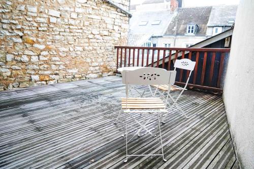 deux chaises et une table sur un balcon dans l'établissement Le Rive Hugo • Élégance & Art de vivre, à Châteauroux
