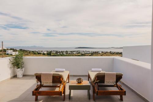 a balcony with two chairs and a view of the ocean at Olive Garden Luxury Resort in Angairiá