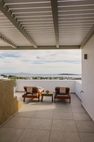a patio with two benches and a view of the ocean at Olive Garden Luxury Resort in Angairiá