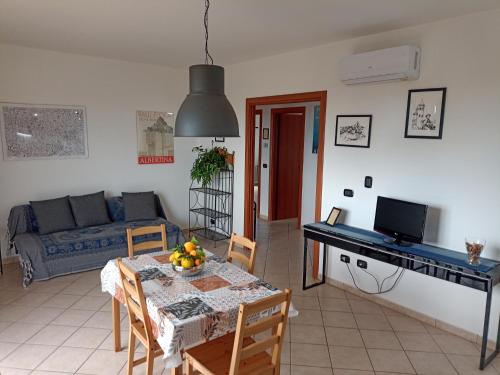 sala de estar con mesa y sofá en Degli Angioini Holiday Home, en Caulonia Marina