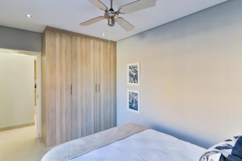 ein Schlafzimmer mit einem Bett und einem Deckenventilator in der Unterkunft Reserved Suites Fourways in Sandton