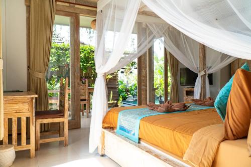 a bedroom with a canopy bed and a balcony at Raditya Villa Ubud in Ubud