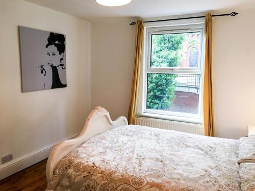een slaapkamer met een bed en een raam bij Pass the Keys Delightful 2 bed apt in Didsbury sleeps 4 in Manchester
