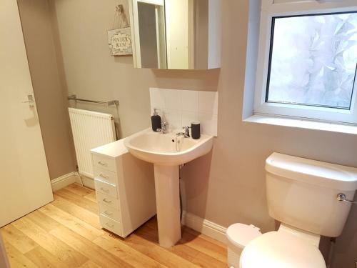 a bathroom with a sink and a toilet at Pass the Keys Delightful 2 bed apt in Didsbury sleeps 4 in Manchester