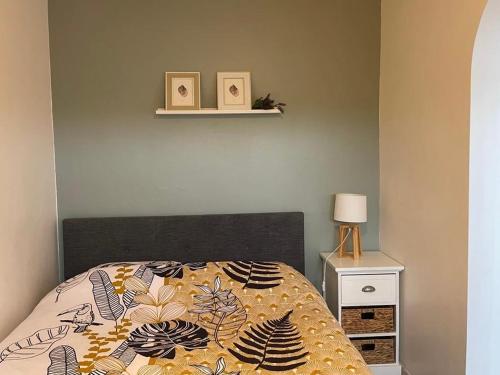 sypialnia z łóżkiem z kołdrą i półką w obiekcie Le Tranquille - Calme - Parking privé w mieście Ambilly