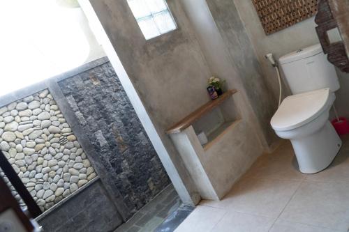 a bathroom with a toilet and a walk in shower at Raditya Villa Ubud in Ubud