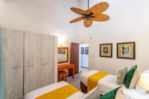 a bedroom with two beds and a ceiling fan at Kruger Park Lodge Unit No. 239 in Hazyview