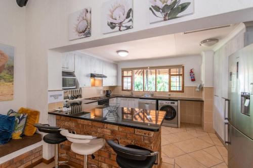 a kitchen with a counter and some stools in it at Kruger Park Lodge Unit No. 239 in Hazyview