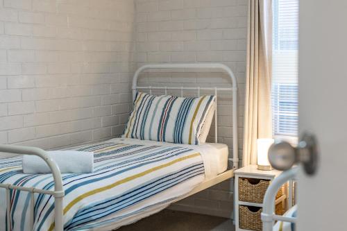 een klein bed in een kamer met een raam bij Sea View Cottage Escape in Middleton
