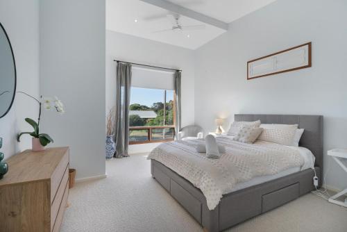um quarto com uma cama e uma grande janela em Sea View Timber Escape em Middleton