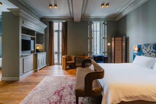 1 dormitorio con 1 cama y sala de estar en Hotel Monastère Maastricht en Maastricht