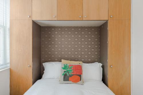 um quarto com uma cama e uma cabeceira em madeira em The Play Pen - Holborn - by Frankie Says em Londres