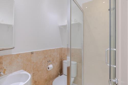 uma casa de banho com um chuveiro, um WC e um lavatório. em The Play Pen - Holborn - by Frankie Says em Londres