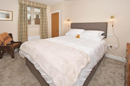 a large white bed in a bedroom with a chair at The Masons Arms in Newcastle under Lyme