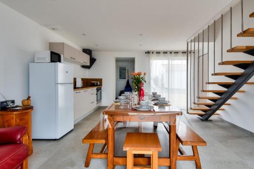 une cuisine et une salle à manger avec une table et un réfrigérateur dans l'établissement Maison pour 6 adultes et 3 enfants - Terrasse, à Noirmoutier-en-l'lle