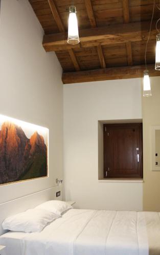 LA LOCANDA DA VITTORIO في Sassa: غرفة نوم بسرير ودهان على الحائط