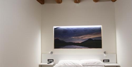 a painting hangs above a bed in a room at LA LOCANDA DA VITTORIO in Sassa