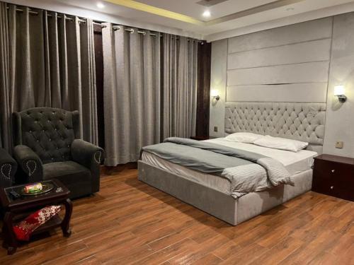 um quarto com uma cama e uma cadeira em Waterstones Hotel em Naran