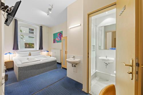 una camera d'albergo con letto e bagno di Hotel Comenius a Berlino