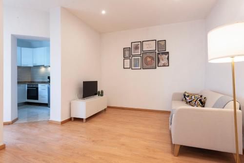 uma sala de estar com um sofá e uma televisão em ALTIDO Warm and Inviting flat with balcony no Porto