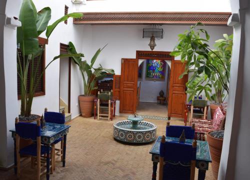sala de estar con sillas azules, mesa y plantas en Dar Mounia, en Rabat