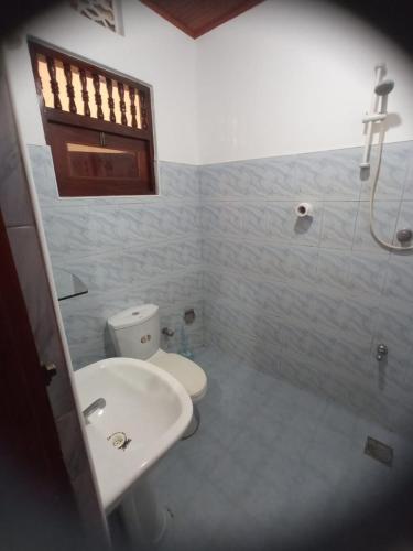 a bathroom with a toilet and a sink and a shower at DAMMI VILLA in Hikkaduwa
