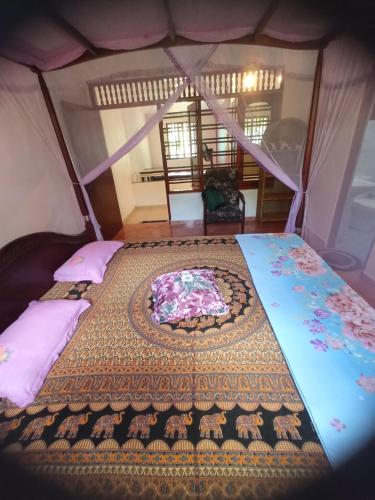 a bedroom with two beds with a bedspread on it at DAMMI VILLA in Hikkaduwa