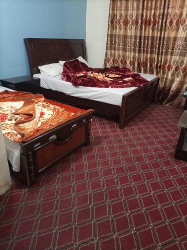 2 camas en una habitación con alfombra roja en Kaghan Valley Hotel, en Naran